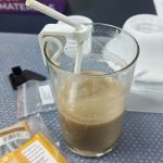 un vaso con café y una pajita sujetada con un soporte impreso en 3D