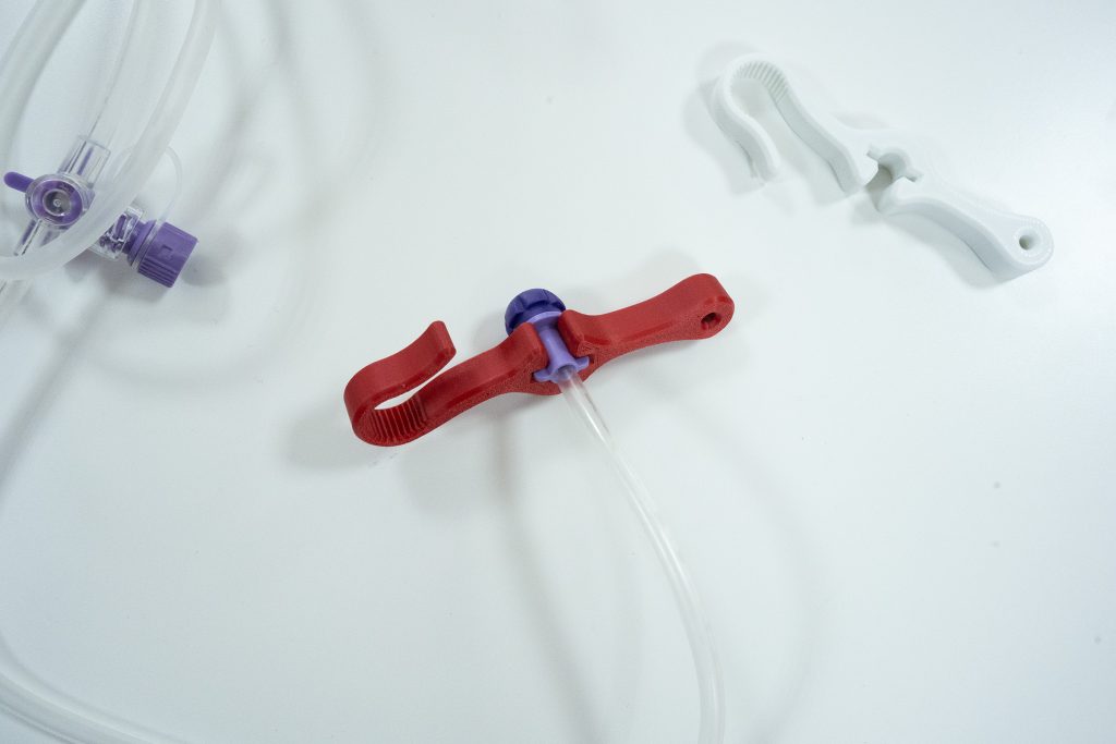 llaves impresas en 3d de color blanco y rojo junto a sonda gástrica y sus conexiones