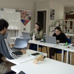 Un grupo de personas asisten a una clase con ordenadores