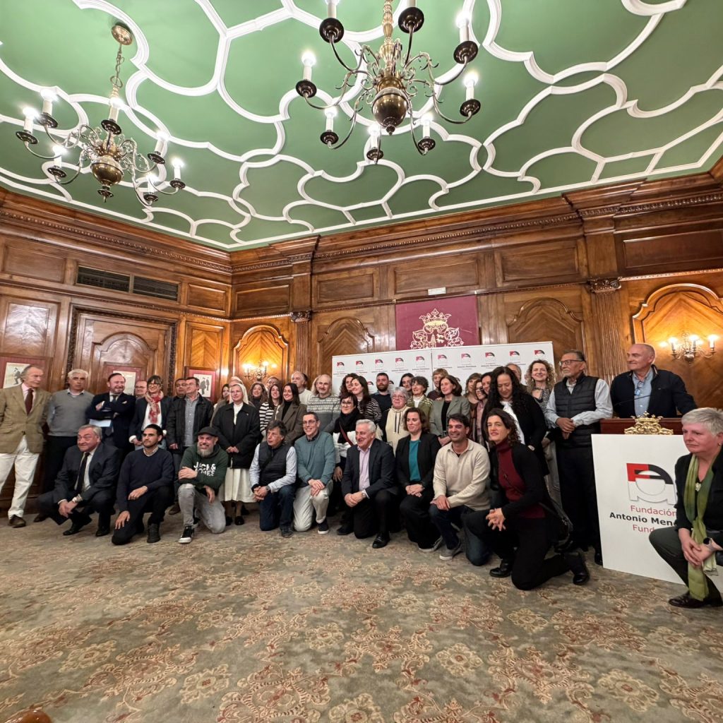 Grupo de personas posan para una fotografía junto a un atril.