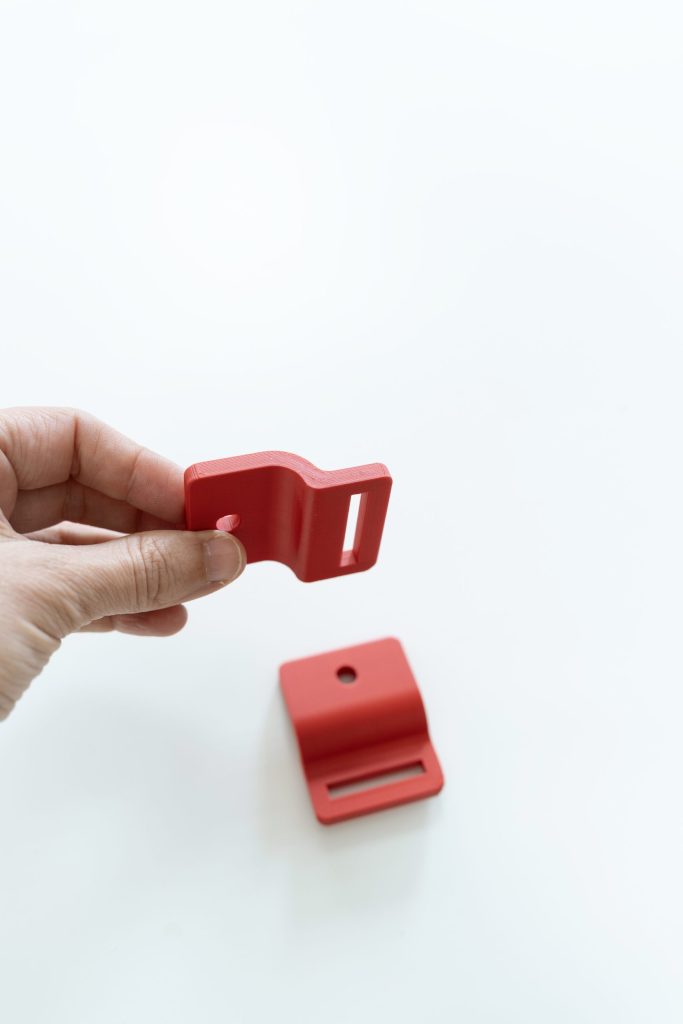 mano sujetando una parte de anclaje a silla de ruedas impresas en 3D